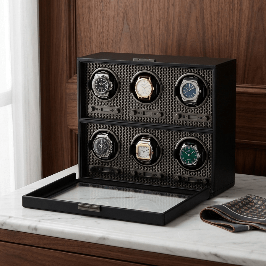 Wolf 1834 Axis watch winder voor 6 horloges in powder coat (mat zwart) afwerking, gevuld met verschillende luxe horloges, op een marmeren dressoir