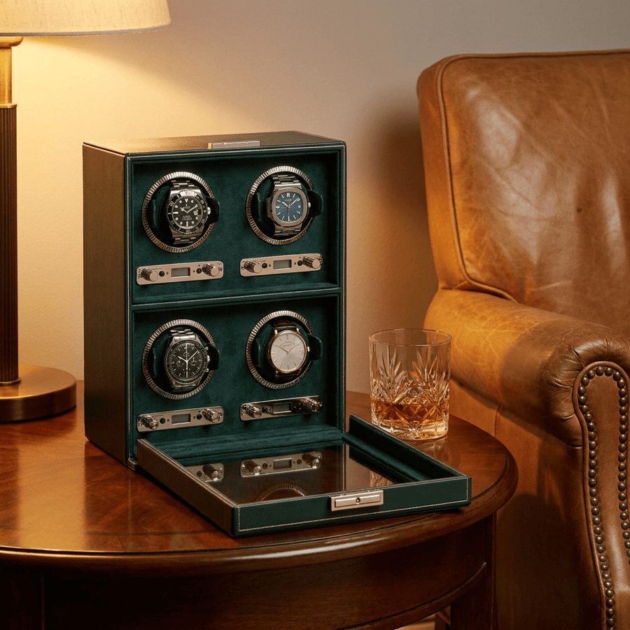 Wolf 1834 British Racing watch winder voor 4 horloges in donkergroen leer, gevuld met verschillende luxe horloges, op een bijzettafel naast een leren fauteuil