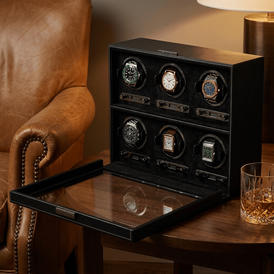 Wolf 1834 British Racing watch winder voor 6 horloges in zwart leer, gevuld met verschillende luxe horloges, op een bijzettafel naast een leren fauteuil